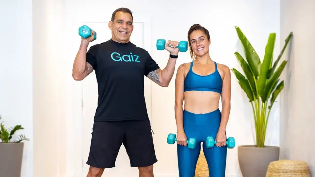 Carol Barcellos e Cesar Parcias treinando com halteres em ação do projeto Carol no Gaiz