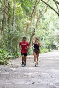Carol Barcellos e Roberto Tadao Dum percorrem uma trilha cercada pela natureza