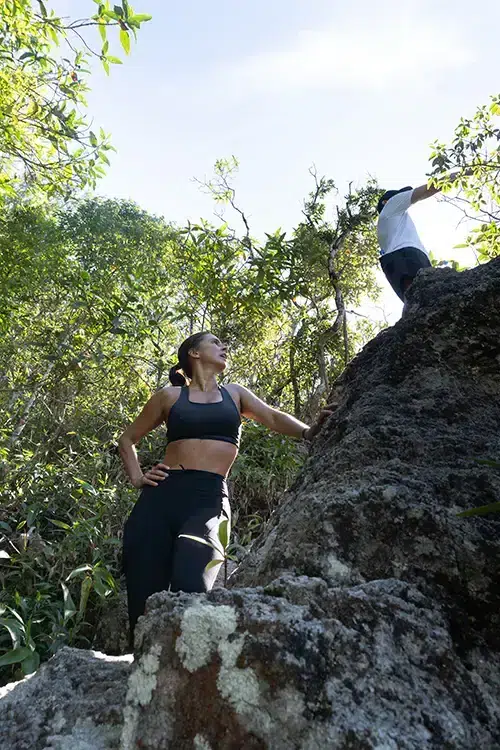 Carol Barcellos durante percurso entre pedras e vegetação no projeto Nas Trilhas